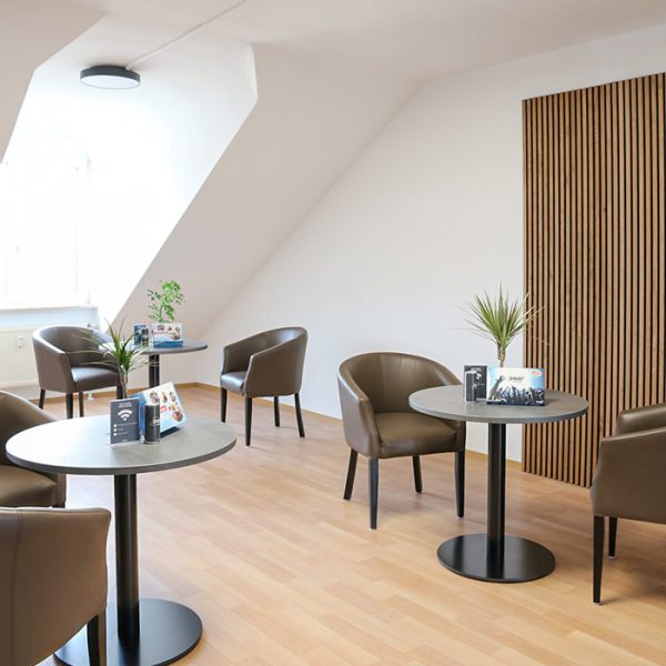Fahrschule VIB Bamberg Cafeteria. Mehrere Tische mit Stühlen, hübsch dekoriert.