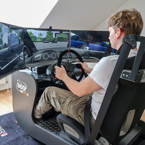 Fahrsimulator der VIB Fahrschule Bamberg. Ein junger Mann nutzt den Simulator für Trainingszwecke.
